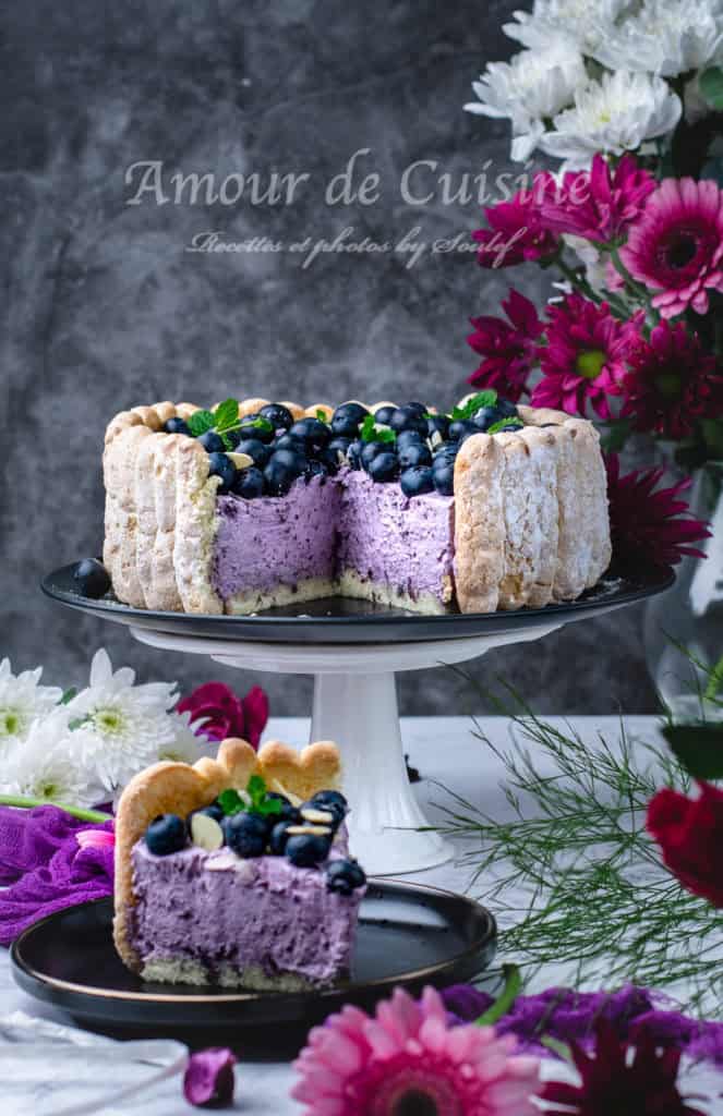 Whole blueberry charlotte with a slice removed, highlighting texture and vibrant mousse inside.