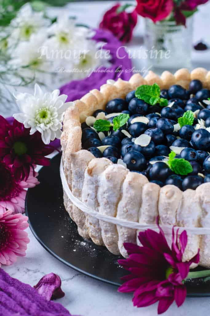 Close-up of biscuit border and topping details on the blueberry charlotte, with floral background.